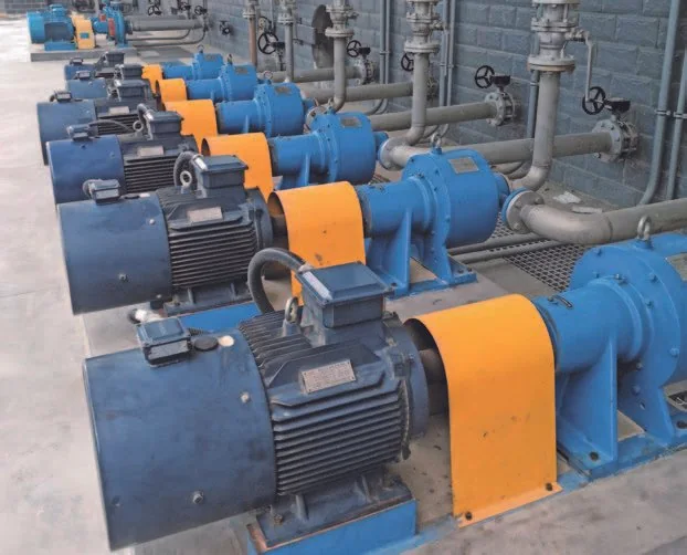 Row of pump and motor assemblies connected to process pipework